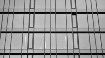 vaso moderno edificio con azul cielo antecedentes. ver y arquitectura detalles. urbano resumen - ventanas de vaso oficina edificio en luz de sol día. negro y blanco. foto