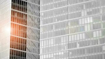 Glass modern building with blue sky background. View and architecture details. Urban abstract - windows of glass office building in  sunlight day. Black and white. photo