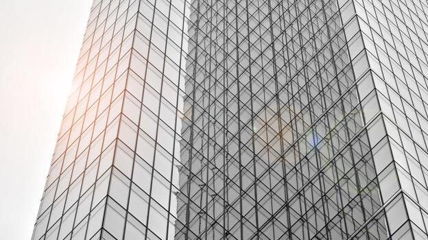 Glass modern building with blue sky background. View and architecture details. Urban abstract - windows of glass office building in  sunlight day. Black and white. photo
