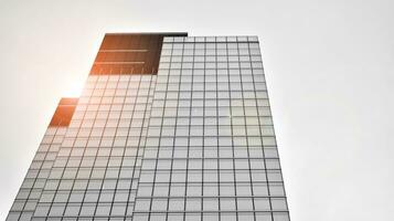 Glass modern building with blue sky background. View and architecture details. Urban abstract - windows of glass office building in  sunlight day. Black and white. photo