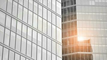 Glass modern building with blue sky background. View and architecture details. Urban abstract - windows of glass office building in  sunlight day. Black and white. photo