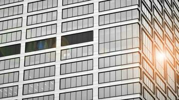 Glass modern building with blue sky background. View and architecture details. Urban abstract - windows of glass office building in  sunlight day. Black and white. photo