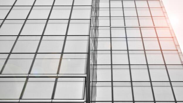 Glass modern building with blue sky background. View and architecture details. Urban abstract - windows of glass office building in  sunlight day. Black and white. photo