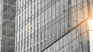 vaso moderno edificio con azul cielo antecedentes. ver y arquitectura detalles. urbano resumen - ventanas de vaso oficina edificio en luz de sol día. negro y blanco. foto