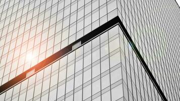 Glass modern building with blue sky background. View and architecture details. Urban abstract - windows of glass office building in  sunlight day. Black and white. photo