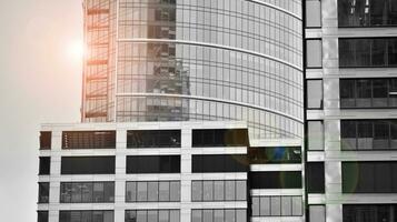 Glass modern building with blue sky background. View and architecture details. Urban abstract - windows of glass office building in  sunlight day. Black and white. photo