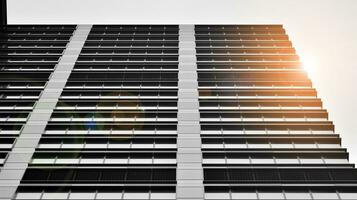 Glass modern building with blue sky background. View and architecture details. Urban abstract - windows of glass office building in  sunlight day. Black and white. photo