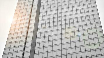 Glass modern building with blue sky background. View and architecture details. Urban abstract - windows of glass office building in  sunlight day. Black and white. photo