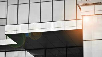 Glass modern building with blue sky background. View and architecture details. Urban abstract - windows of glass office building in  sunlight day. Black and white. photo