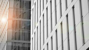 Glass modern building with blue sky background. View and architecture details. Urban abstract - windows of glass office building in  sunlight day. Black and white. photo