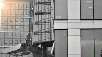 Glass modern building with blue sky background. View and architecture details. Urban abstract - windows of glass office building in  sunlight day. Black and white. photo