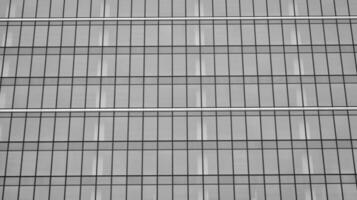 vaso moderno edificio con azul cielo antecedentes. ver y arquitectura detalles. urbano resumen - ventanas de vaso oficina edificio en luz de sol día. negro y blanco. foto