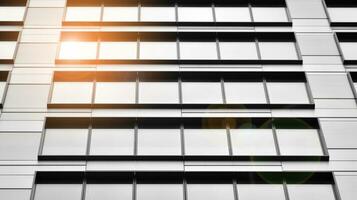 Glass modern building with blue sky background. View and architecture details. Urban abstract - windows of glass office building in  sunlight day. Black and white. photo