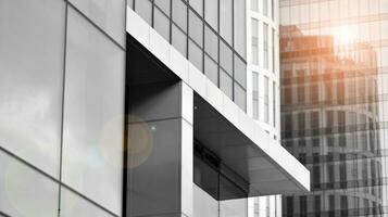 Glass modern building with blue sky background. View and architecture details. Urban abstract - windows of glass office building in  sunlight day. Black and white. photo