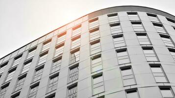 Glass modern building with blue sky background. View and architecture details. Urban abstract - windows of glass office building in  sunlight day. Black and white. photo