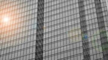 Glass modern building with blue sky background. View and architecture details. Urban abstract - windows of glass office building in  sunlight day. Black and white. photo