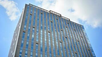 Glass building with transparent facade of the building and blue sky. Structural glass wall reflecting blue sky. Abstract modern architecture fragment. Contemporary architectural background. photo