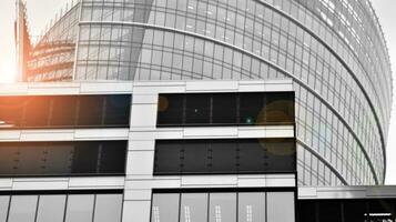 Glass modern building with blue sky background. View and architecture details. Urban abstract - windows of glass office building in  sunlight day. Black and white. photo