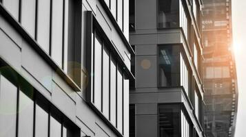 Glass modern building with blue sky background. View and architecture details. Urban abstract - windows of glass office building in  sunlight day. Black and white. photo