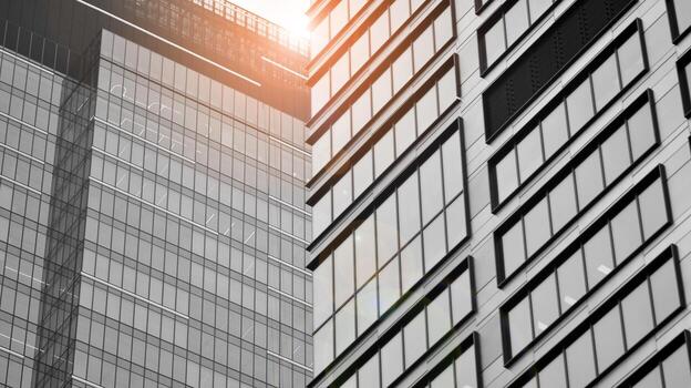 Glass modern building with blue sky background. View and architecture details. Urban abstract - windows of glass office building in  sunlight day. Black and white. photo
