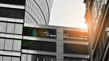 Glass modern building with blue sky background. View and architecture details. Urban abstract - windows of glass office building in  sunlight day. Black and white. photo