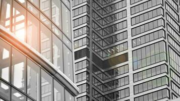 Glass modern building with blue sky background. View and architecture details. Urban abstract - windows of glass office building in  sunlight day. Black and white. photo