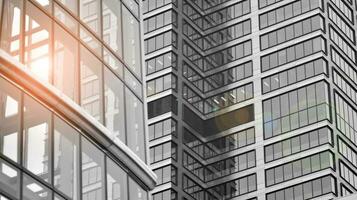 Glass modern building with blue sky background. View and architecture details. Urban abstract - windows of glass office building in  sunlight day. Black and white. photo