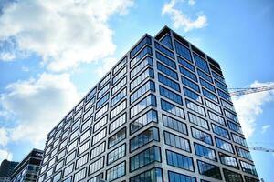 Glass building with transparent facade of the building and blue sky. Structural glass wall reflecting blue sky. Abstract modern architecture fragment. Contemporary architectural background. photo