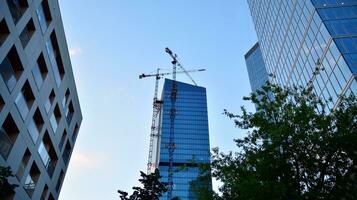 View of a skyscraper under construction. Modern architecture background. Building a high-rise building,  the concept of real estate construction. photo