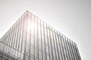 Modern office building with glass facade on a clear sky background. Abstract close up of the glass-clad facade of a modern building covered in reflective plate glass. Black and white. photo