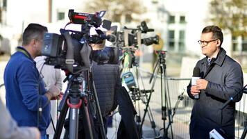 Warsaw, Poland. 24 October 2023. Group of professional journalists and reporters with video and photo camera do reportage and live stream. The presidential palace.