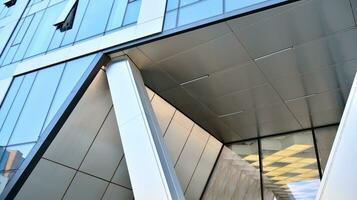 Combination of metal and glass wall material. Steel facade on columns. Abstract modern architecture. High-tech minimalist office building. Contemporary business architecture abstract fragment. photo