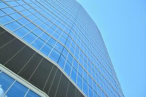 Bottom view of modern skyscrapers in business district against blue sky. Looking up at business buildings in downtown. photo