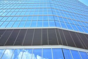 Bottom view of modern skyscrapers in business district against blue sky. Looking up at business buildings in downtown. photo