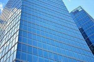 Bottom view of modern skyscrapers in business district against blue sky. Looking up at business buildings in downtown. photo