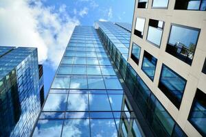 fondo ver de moderno rascacielos en negocio distrito en contra azul cielo. mirando arriba a negocio edificios en centro. foto