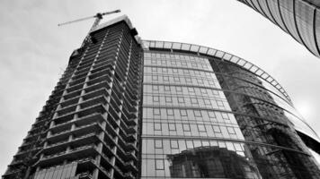 ver de un rascacielos debajo construcción. moderno arquitectura antecedentes. edificio un Alto edificio, el concepto de real inmuebles construcción. negro y blanco. foto