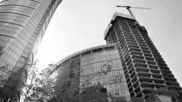 ver de un rascacielos debajo construcción. moderno arquitectura antecedentes. edificio un Alto edificio, el concepto de real inmuebles construcción. negro y blanco. foto