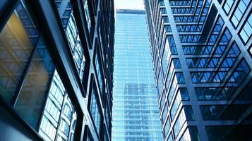 Bottom view of modern skyscrapers in business district against blue sky. Looking up at business buildings in downtown. photo