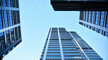 Bottom view of modern skyscrapers in business district against blue sky. Looking up at business buildings in downtown. photo