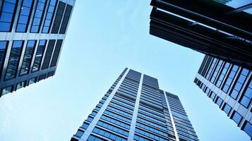 Bottom view of modern skyscrapers in business district against blue sky. Looking up at business buildings in downtown. photo