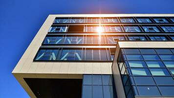 Structural glass wall reflecting blue sky. Abstract modern architecture fragment. Glass building with transparent facade of the building and blue sky. Contemporary architectural background. photo