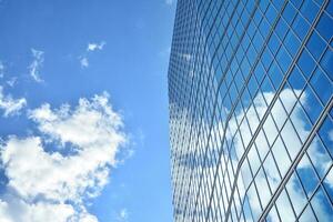 Modern office building with glass facade on a clear sky background. Transparent glass wall of office building. photo