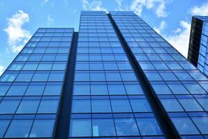 Modern office building with glass facade on a clear sky background. Transparent glass wall of office building. photo