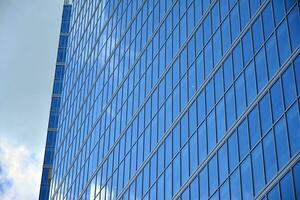 moderno oficina edificio con vaso fachada en un claro cielo antecedentes. transparente vaso pared de oficina edificio. foto