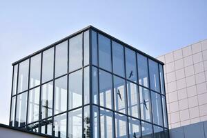 Modern office building with glass facade on a clear sky background. Transparent glass wall of office building. photo