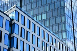 Modern office building with glass facade on a clear sky background. Transparent glass wall of office building. photo