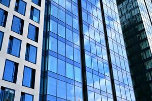 moderno oficina edificio con vaso fachada en un claro cielo antecedentes. transparente vaso pared de oficina edificio. foto