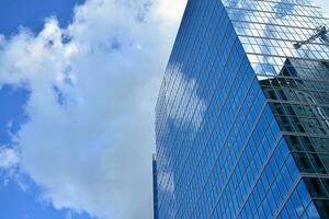 Modern office building with glass facade on a clear sky background. Transparent glass wall of office building. photo