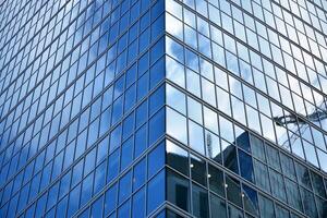 Modern office building with glass facade on a clear sky background. Transparent glass wall of office building. photo